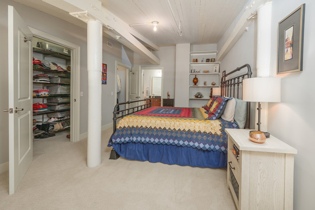 1201 Front Avenue, Unit 509 Columbus, GA 31901 - Photo 33 of 41 a bed sitting in a bedroom next to a lamp