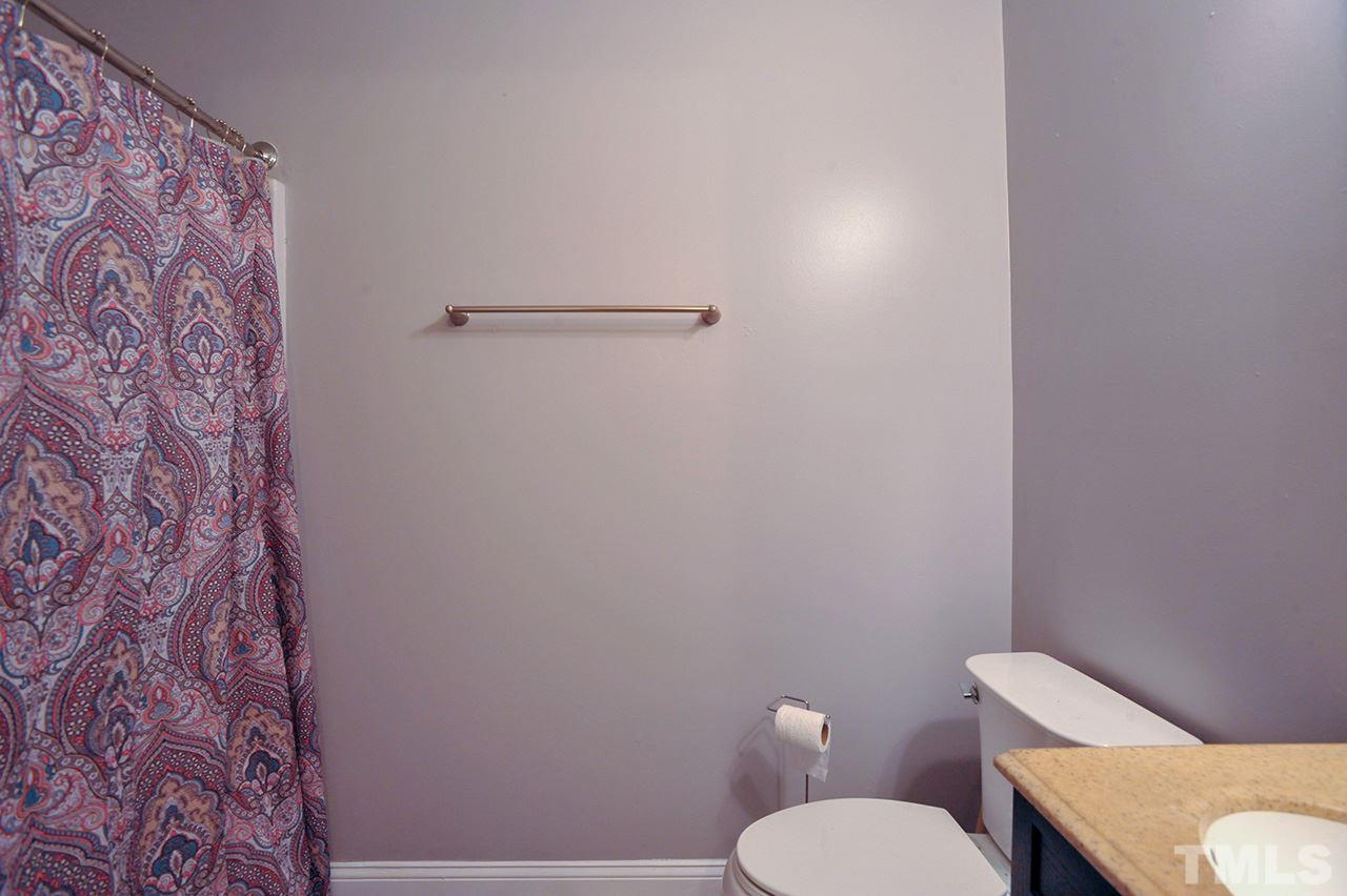 4604 Old Poole Road Raleigh, NC 27610 - Photo 13 of 14 a white toilet sitting next to a shower curtain