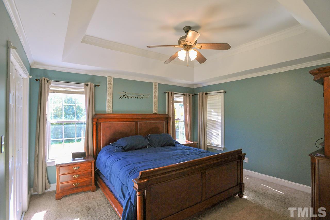 4604 Old Poole Road Raleigh, NC 27610 - Photo 6 of 14 a bedroom with a large bed and a chandelier