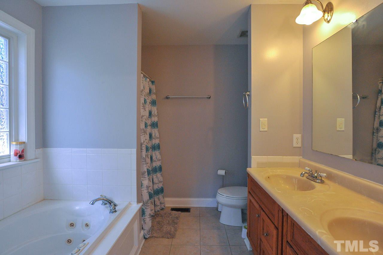 4604 Old Poole Road Raleigh, NC 27610 - Photo 8 of 14 a bathroom with a tub sink toilet and mirror