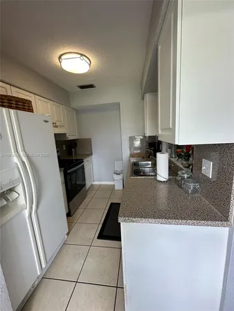 a kitchen with a refrigerator sink and stove