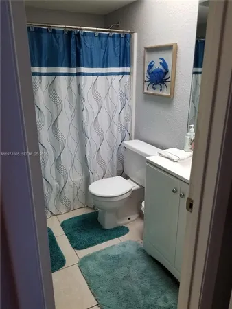 a bathroom with a toilet and a shower curtain