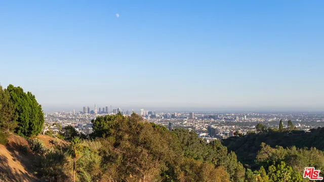 a view of a patio with couches and table and chairs and potted plants