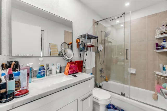 a bathroom with a sink toilet vanity and shower