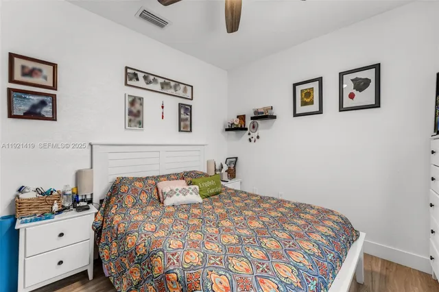 a bedroom with a bed and painting on the wall