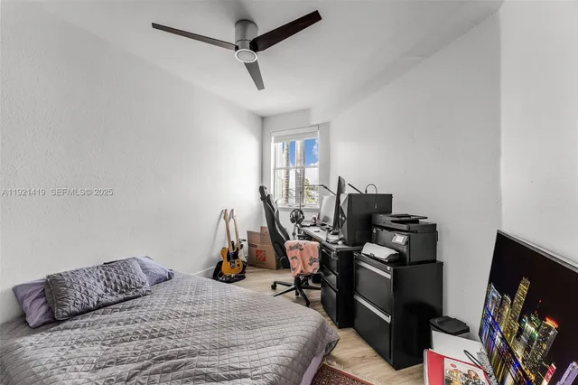 a bedroom that has a bed and a flat tv screen on the dresser