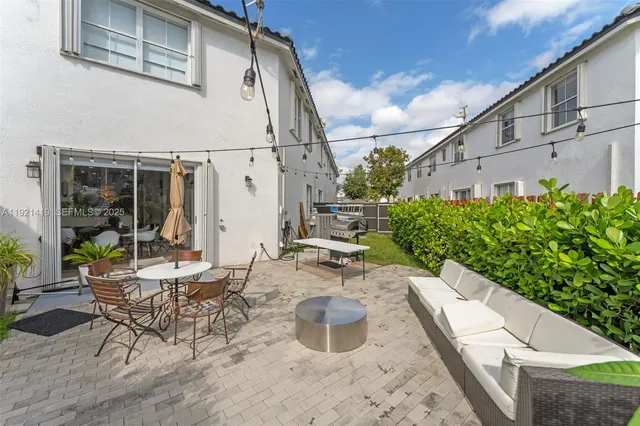 a view of a patio with table and chairs potted plants