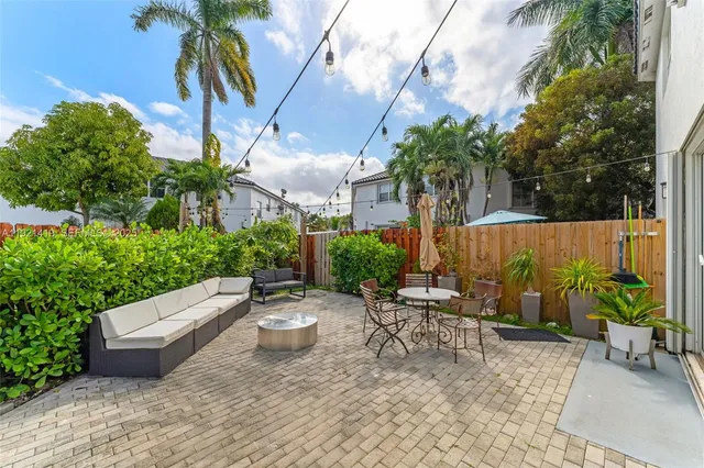 an outdoor sitting area with couch and potted plants