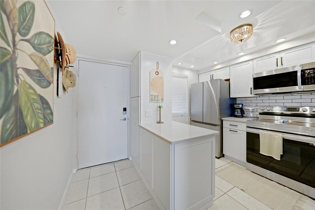 1591 Beach Road, Unit 202 Englewood, FL 34223 - Photo 11 of 46 a kitchen with stainless steel appliances a refrigerator and a stove top oven