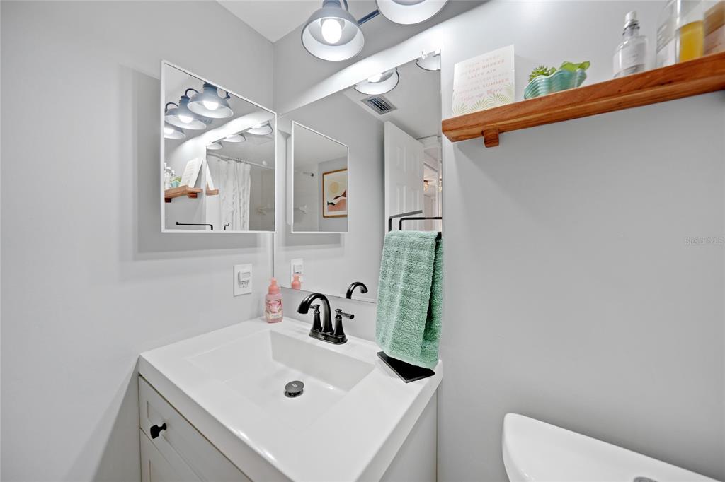 1591 Beach Road, Unit 202 Englewood, FL 34223 - Photo 22 of 46 a bathroom with a sink a toilet and mirror