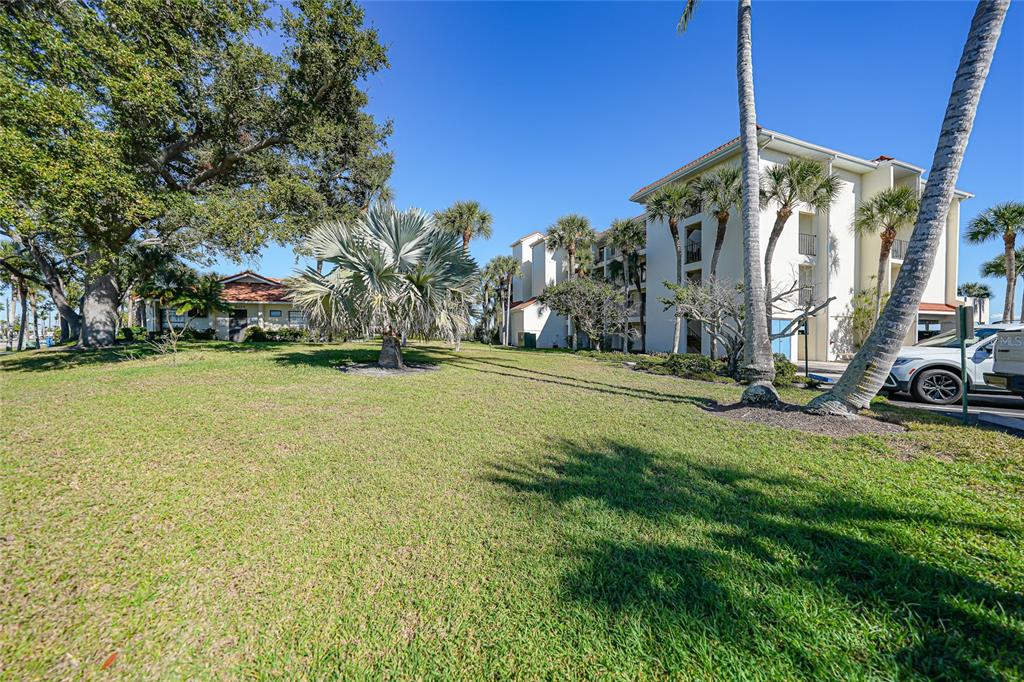 1591 Beach Road, Unit 202 Englewood, FL 34223 - Photo 37 of 46 a view of a street with a building and a big yard