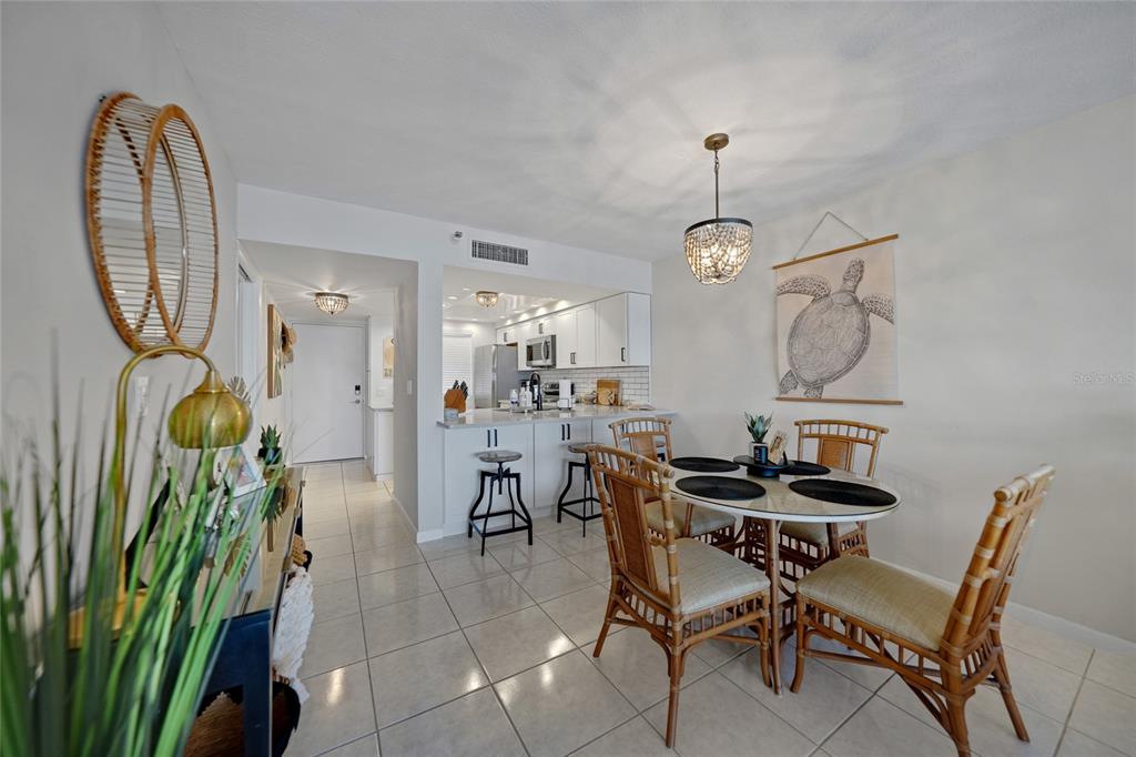 1591 Beach Road, Unit 202 Englewood, FL 34223 - Photo 7 of 46 a dining room with furniture a rug and a chandelier