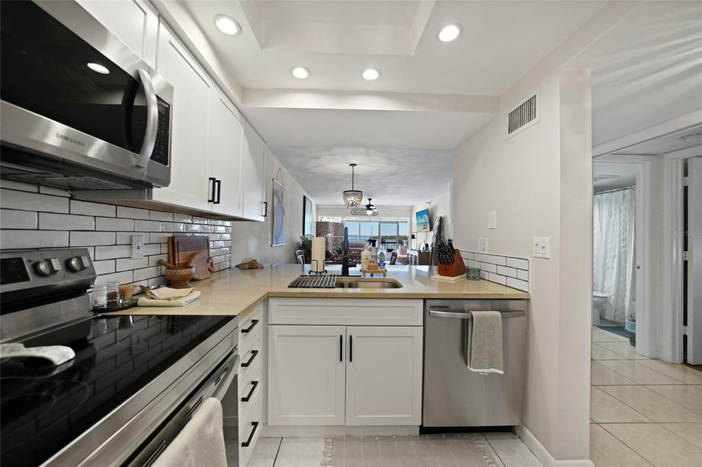 1591 Beach Road, Unit 202 Englewood, FL 34223 - Photo 8 of 46 a kitchen with a sink stove and cabinets