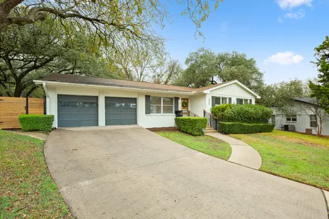 a front view of a house with yard and green space