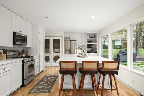 a large kitchen with a table and chairs