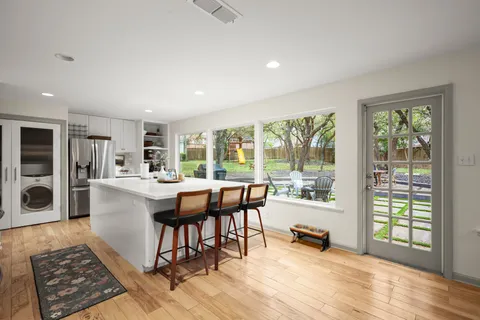 a living room with furniture and large windows with wooden floor