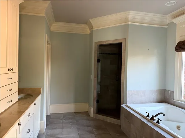 a bathroom with a tub a sink and a mirror