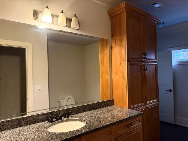 a bathroom with a granite countertop sink and a mirror