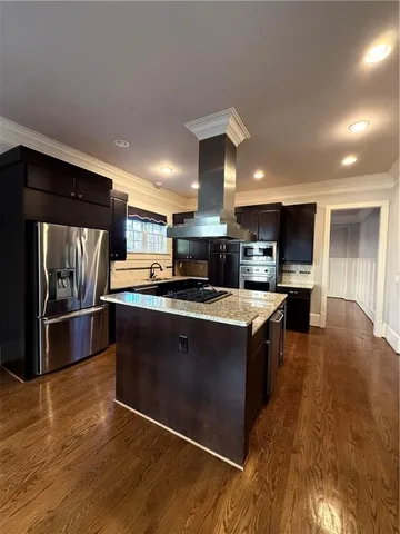 a large kitchen with stainless steel appliances and a large counter top