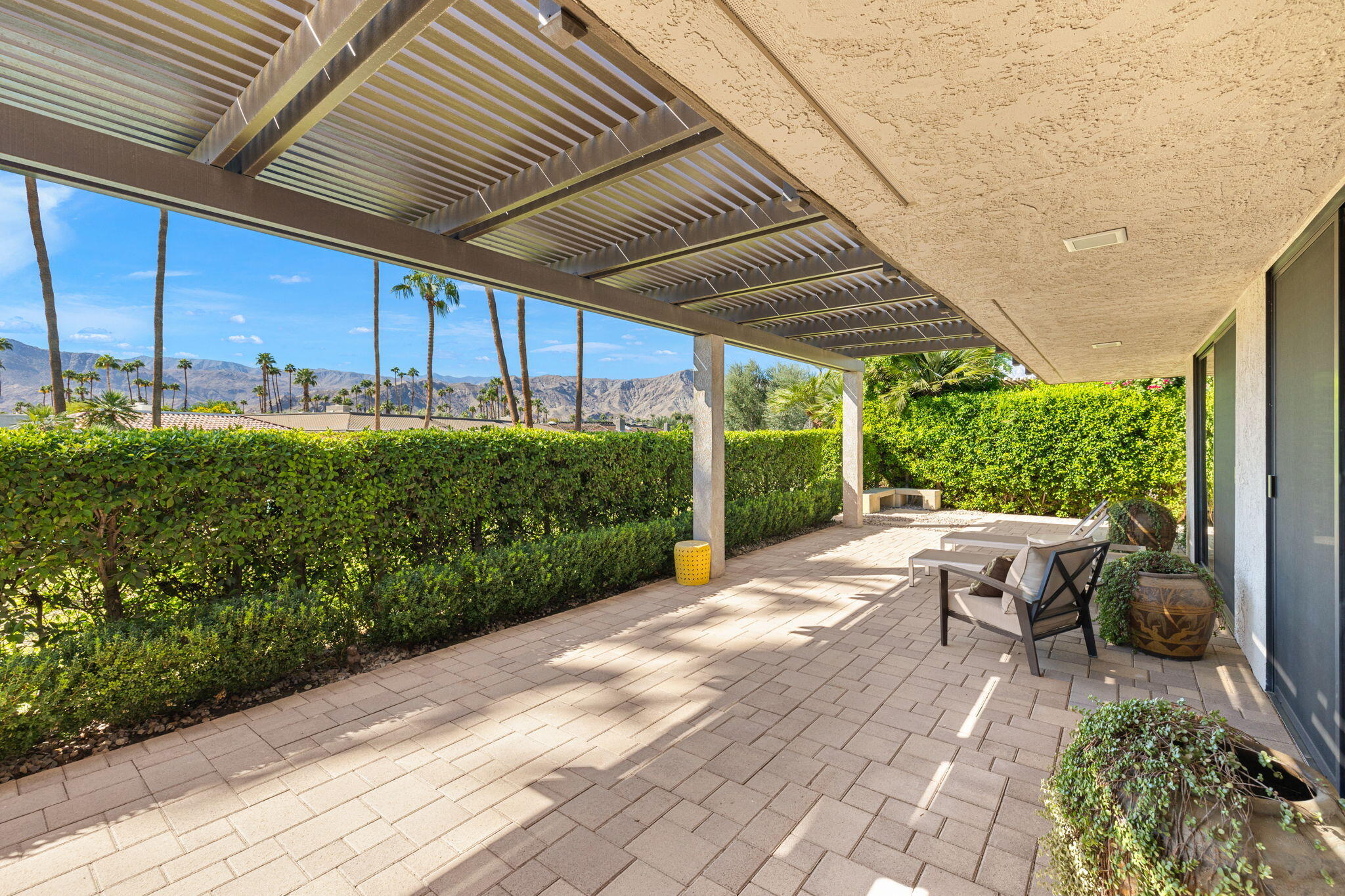 15 Reed Court Rancho Mirage, CA 92270 - Photo 45 of 53 a view of a patio with table and chairs potted plants with wooden floor and fence