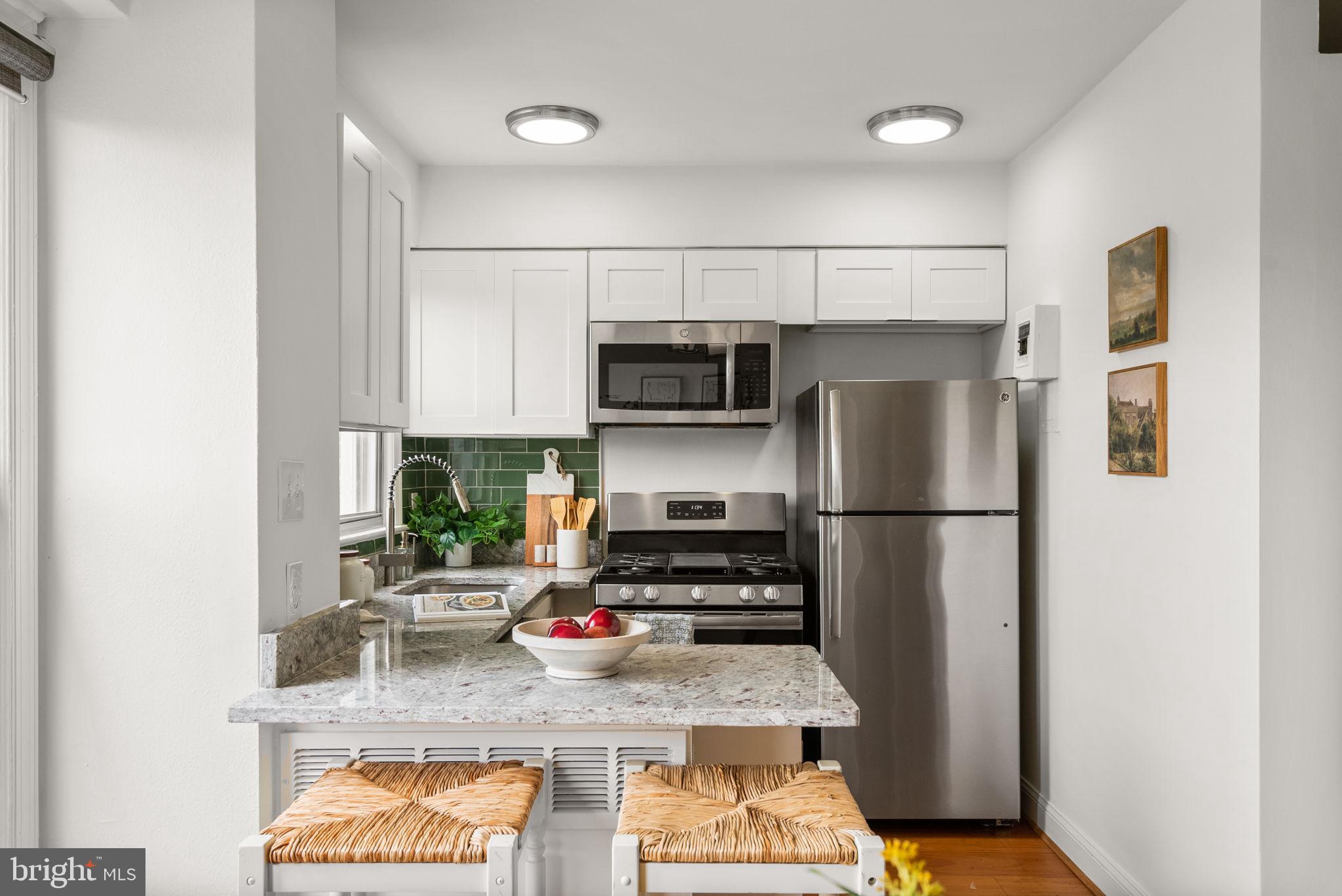 2500 Q Street Northwest, Unit 524 Washington, DC 20007 - Photo 25 of 50 a kitchen with stainless steel appliances granite countertop a refrigerator sink stove and microwave
