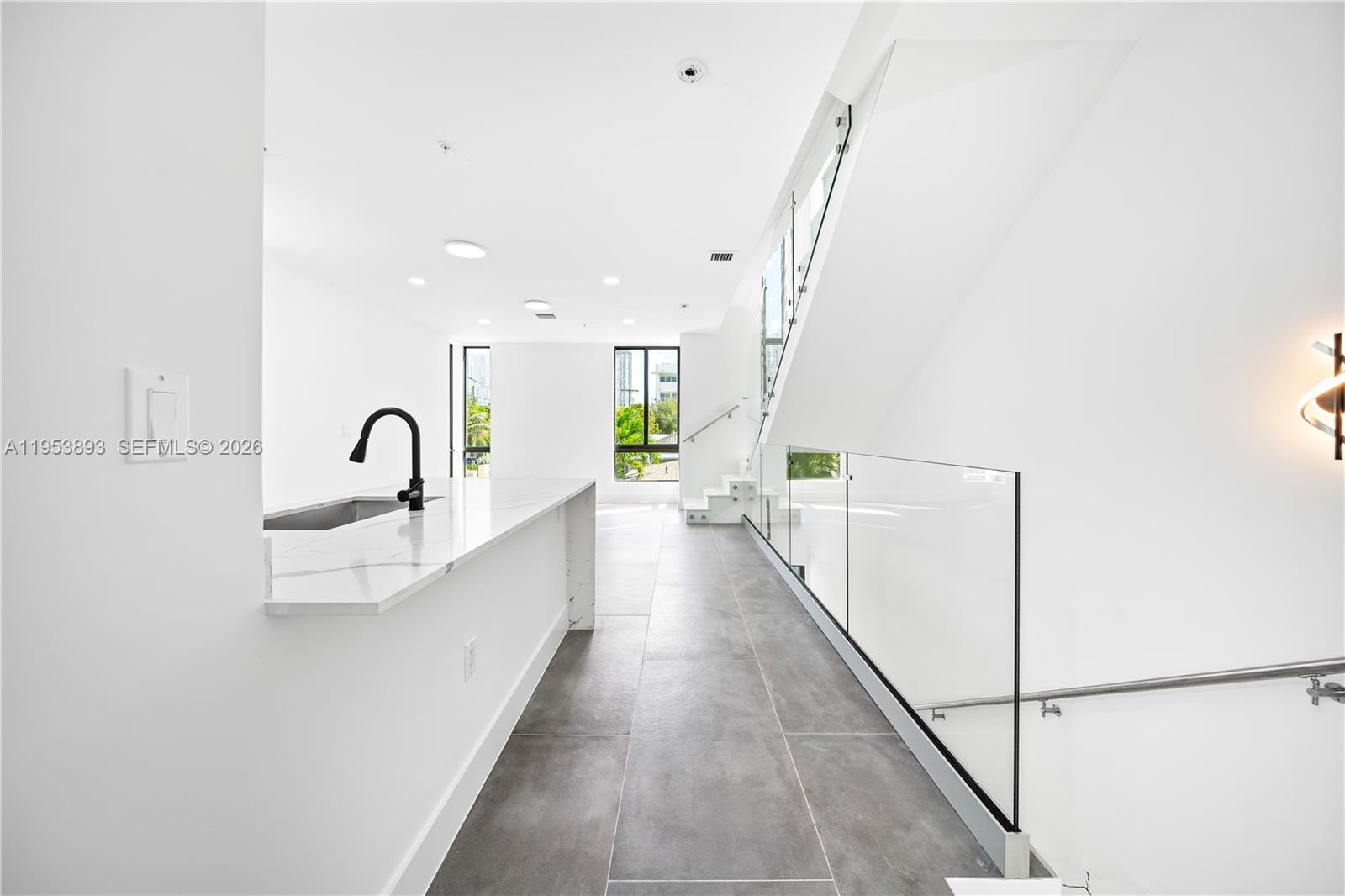 526 Southwest 2nd Street, Unit 5 Miami, FL 33130 - Photo 5 of 27 a view of a kitchen with kitchen island a sink wooden floor and a large window