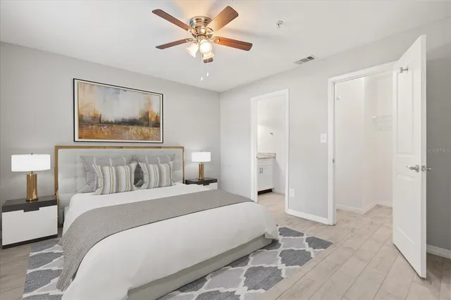 a bedroom with a large bed and a chandelier