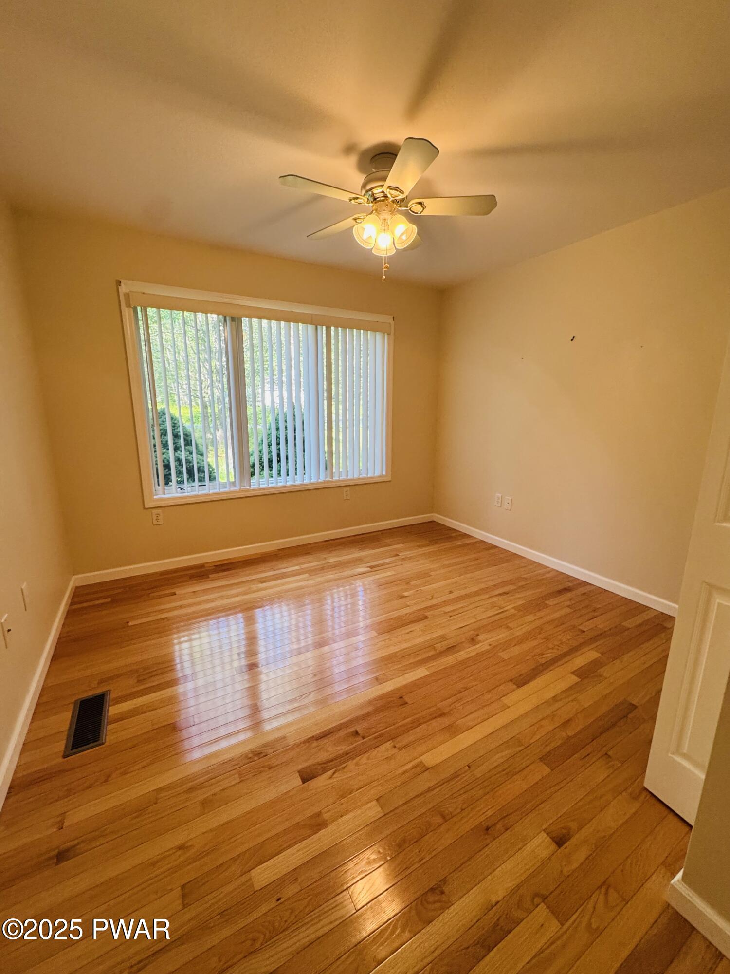 137 Rodeo Drive Hawley, PA 18428 - Photo 28 of 68 a view of an empty room with wooden floor and fan