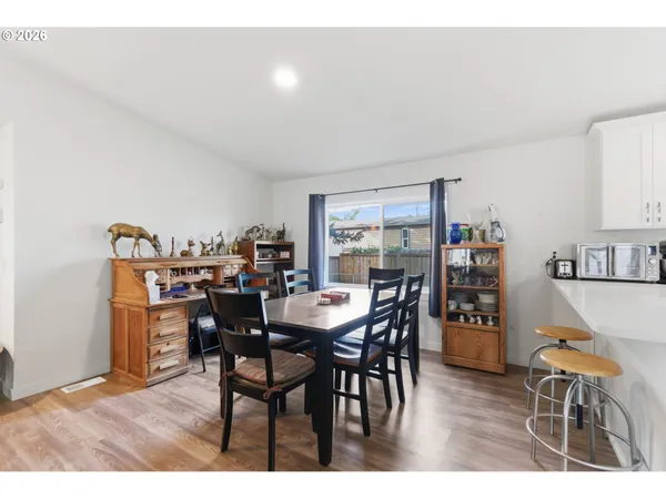 a dining hall with stainless steel appliances kitchen island a table and chairs