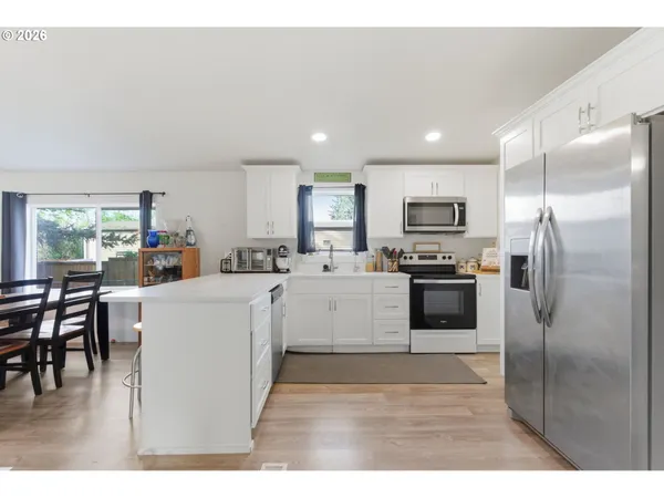 a kitchen that has a lot of cabinets in it and wooden floors