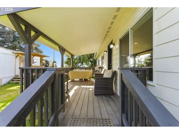 a balcony with wooden floor and outdoor seating
