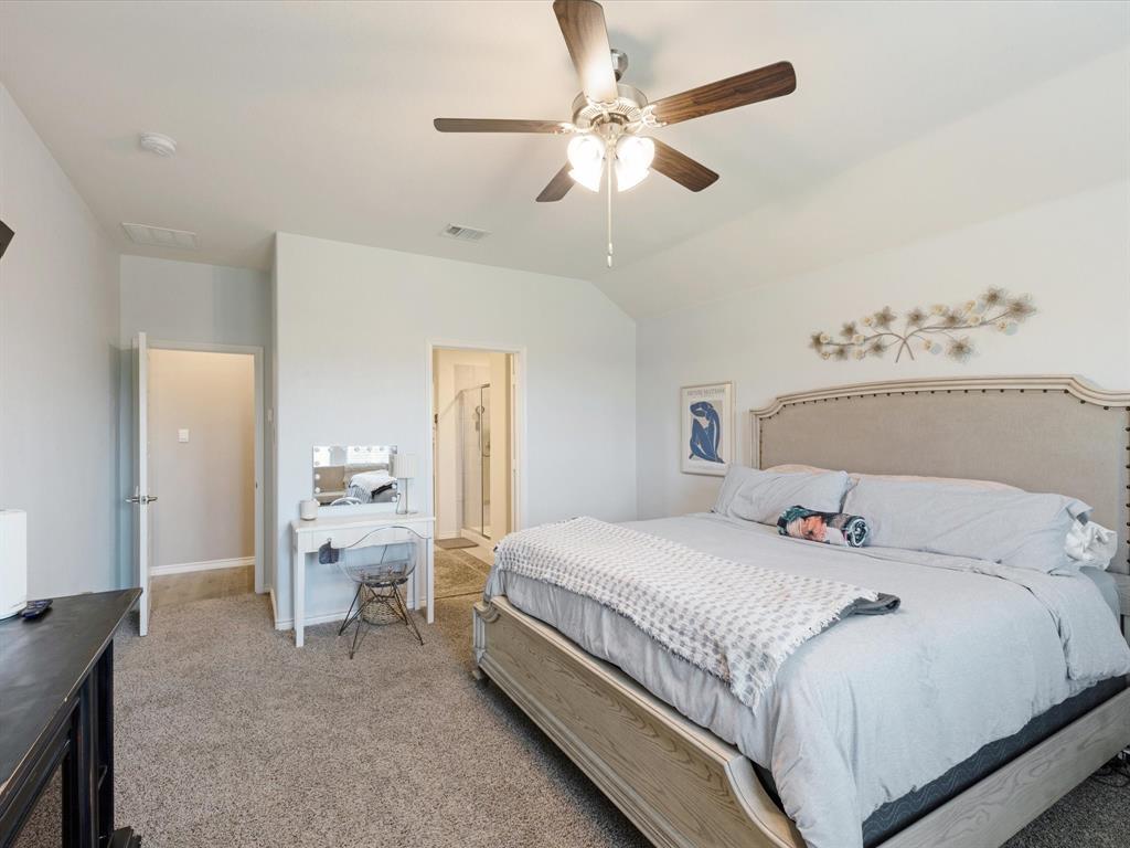 3257 Trails End Road Aubrey, TX 76227 - Photo 14 of 37 a bedroom with a bed and a chandelier