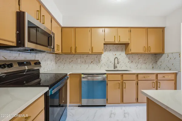 a kitchen with stainless steel appliances granite countertop a sink stove and microwave