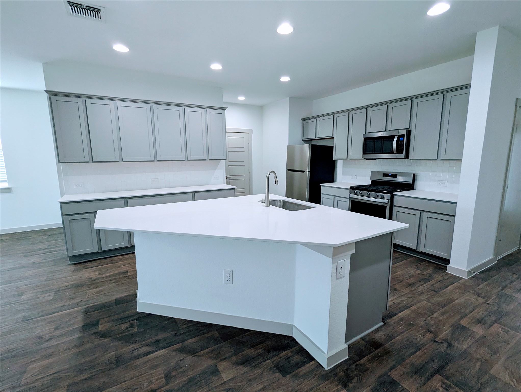 13804 Clerk Street Pflugerville, TX 78660 - Photo 1 of 14 a kitchen with kitchen island a sink stainless steel appliances and cabinets