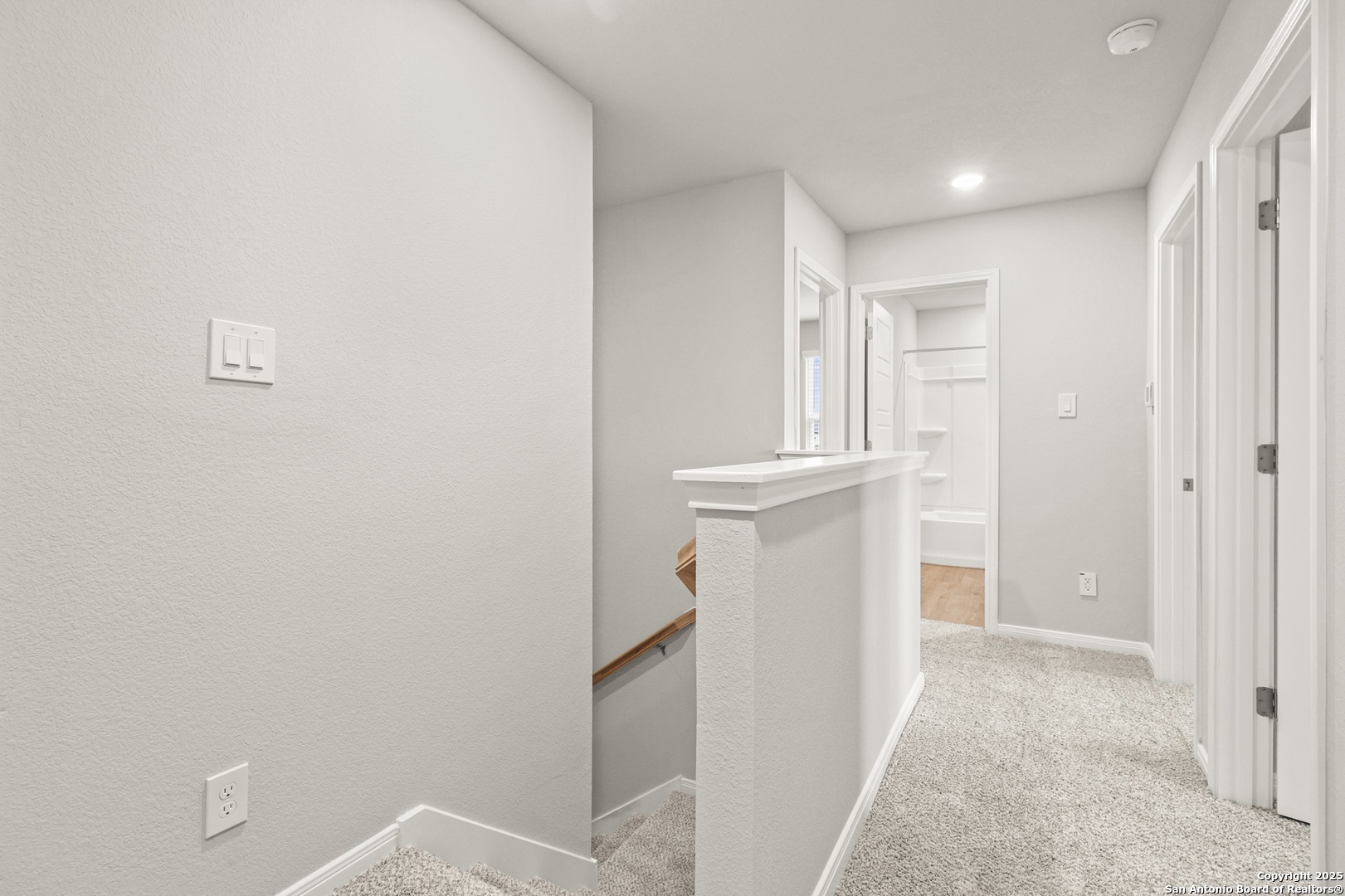 418 Cross Barn Boulevard, Unit B Buda, TX 78610 - Photo 23 of 35 a view of a hallway with white cabinets and a refrigerator