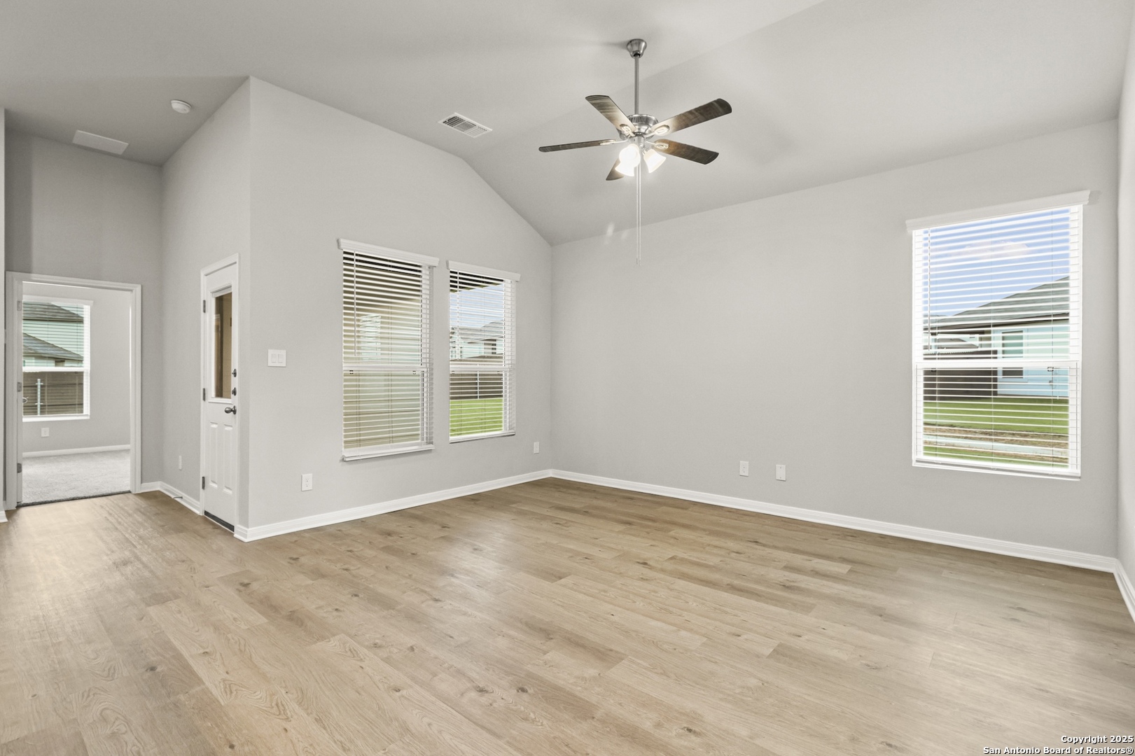 418 Cross Barn Boulevard, Unit B Buda, TX 78610 - Photo 3 of 35 an empty room with wooden floor chandelier fan and windows
