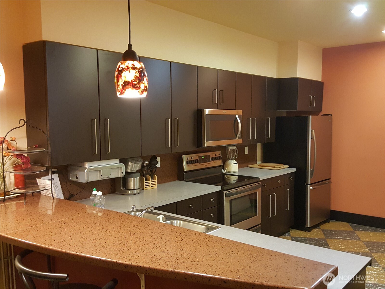 668 South Lane Street, Unit 314 Seattle, WA 98104 - Photo 21 of 23 a kitchen with stainless steel appliances a microwave a sink and a refrigerator