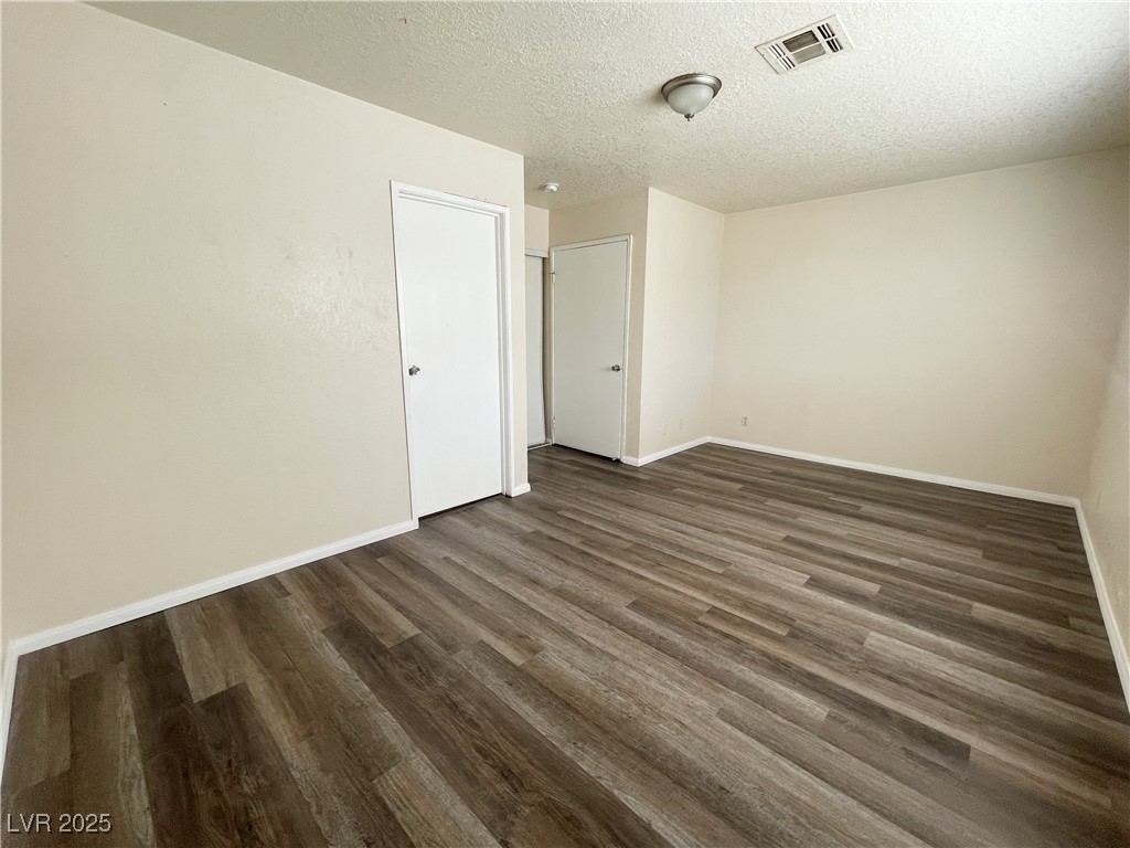 6917 Mendon Lane, Unit 4 Las Vegas, NV 89156 - Photo 5 of 12 Empty room with dark wood-style flooring and a tex