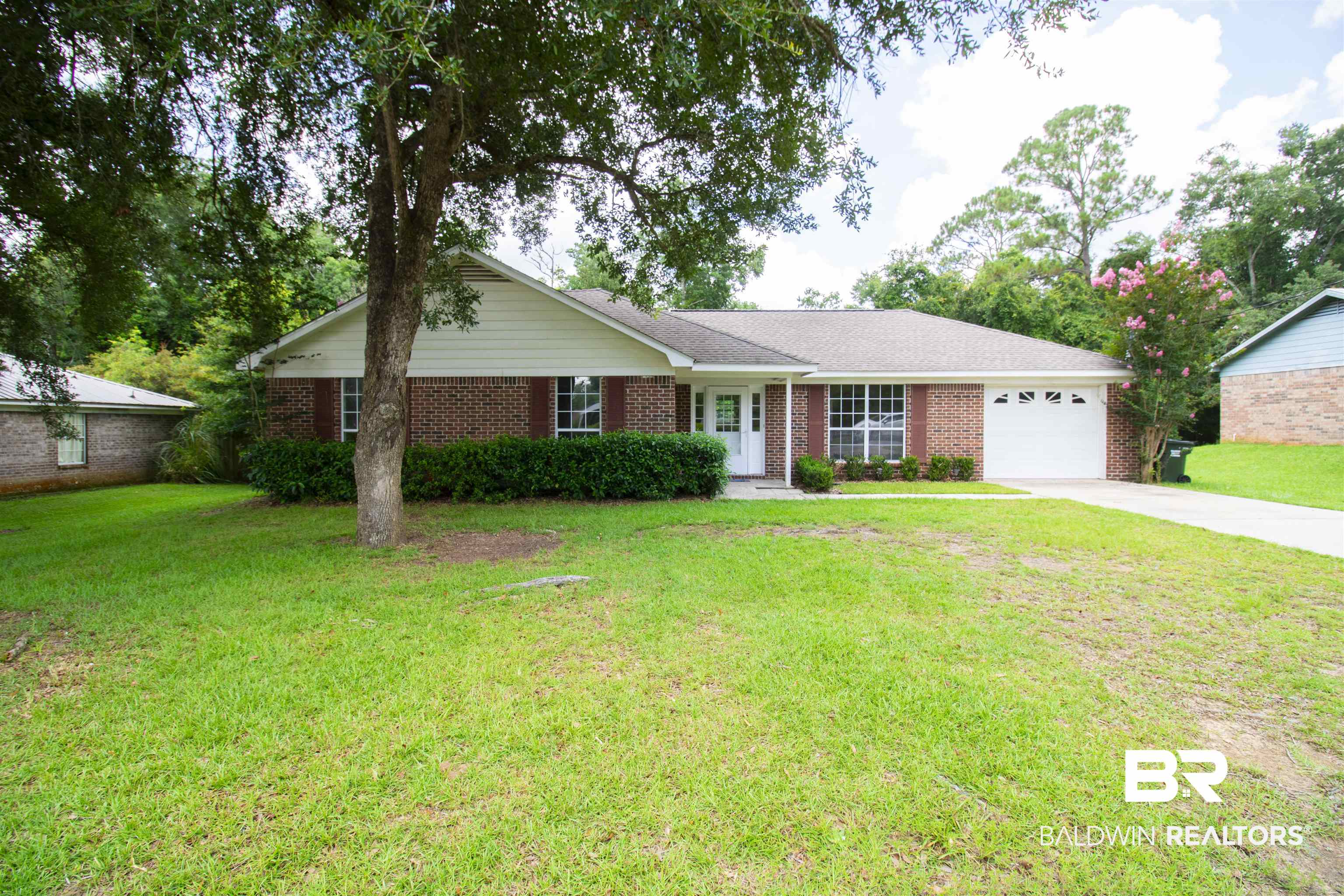 Single story home with a garage and a front yard