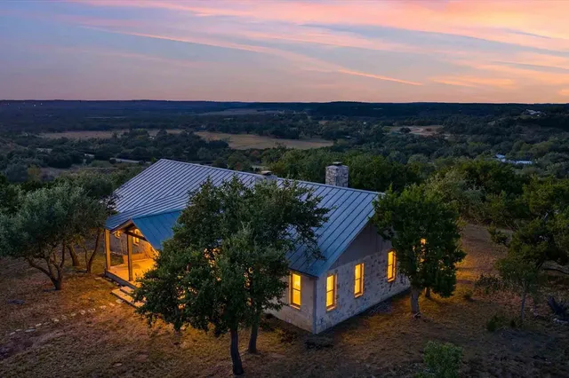 a view of backyard with large tree and wooden fence