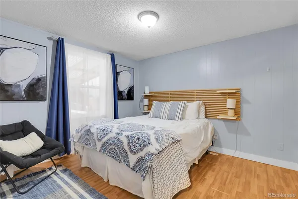 a bedroom with a bed and wooden floor
