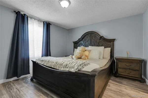a bedroom with a bed and wooden floor