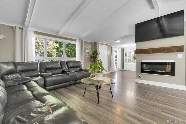 a living room with furniture a flat screen tv and a fireplace