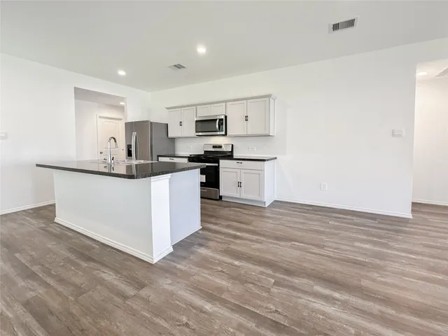 a kitchen with stainless steel appliances a sink stove and cabinets