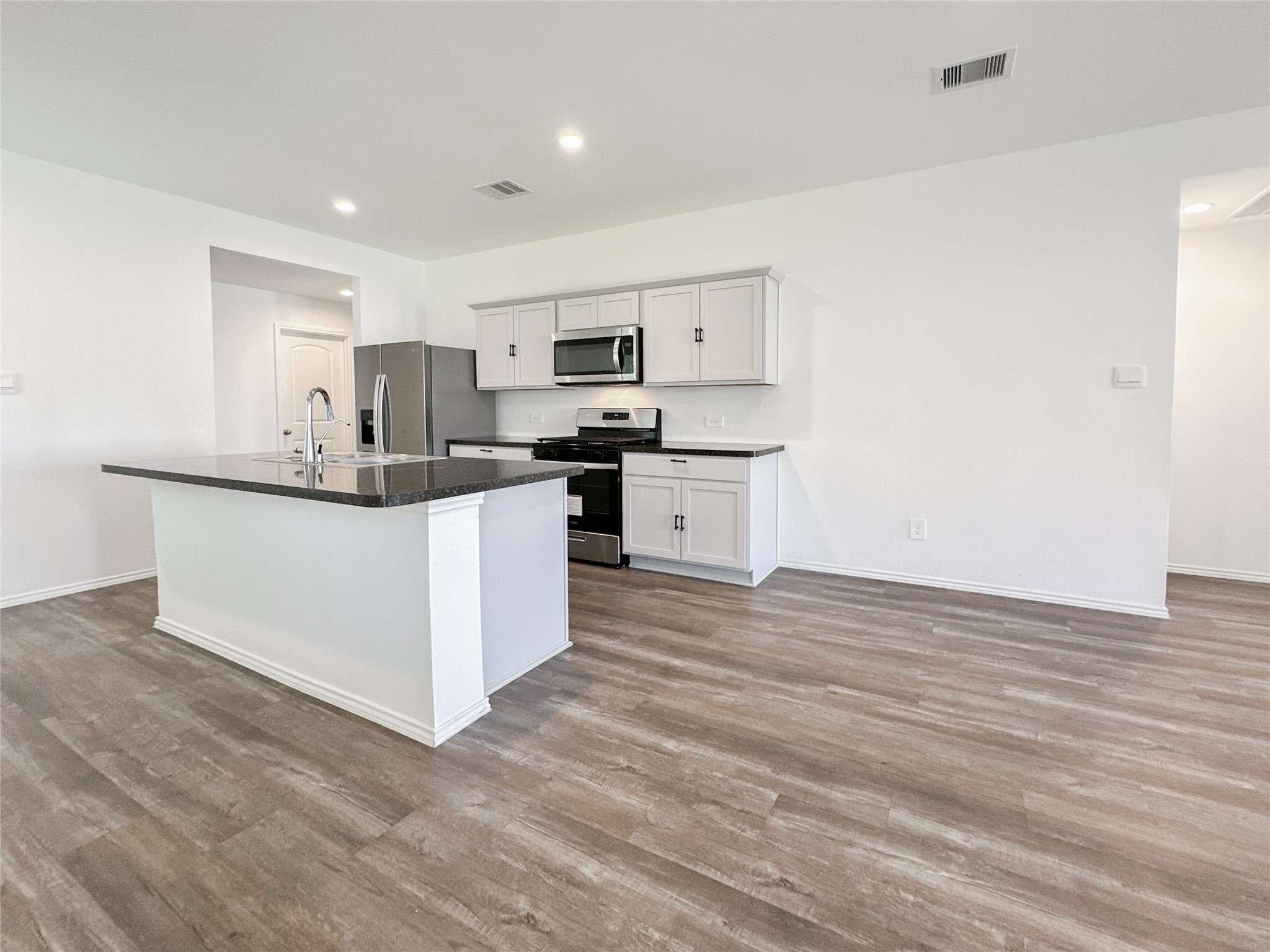 5715 Vintage Oakmont Drive Spring, TX 77373 - Photo 11 of 39 a kitchen with stainless steel appliances a sink stove and cabinets