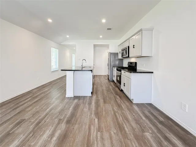 a kitchen with granite countertop a sink and steel appliances