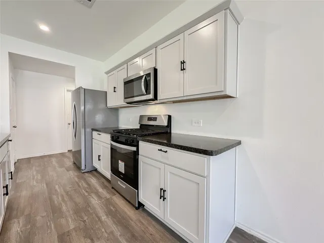 a kitchen with stainless steel appliances granite countertop a stove a sink and a refrigerator