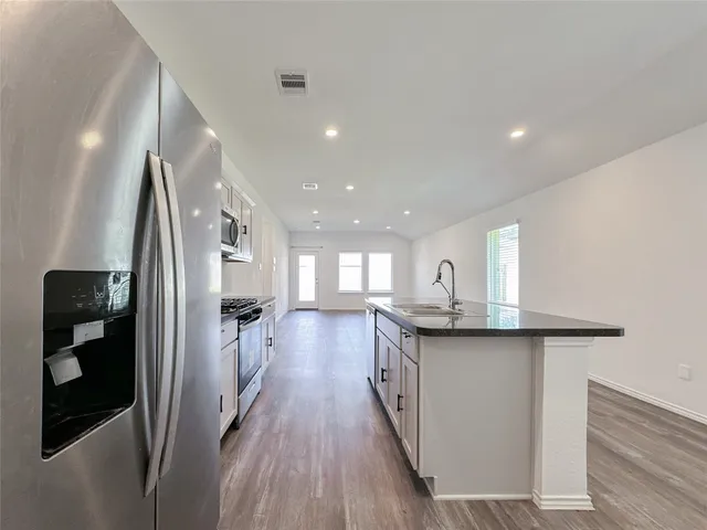 a kitchen with stainless steel appliances granite countertop a sink stove and refrigerator