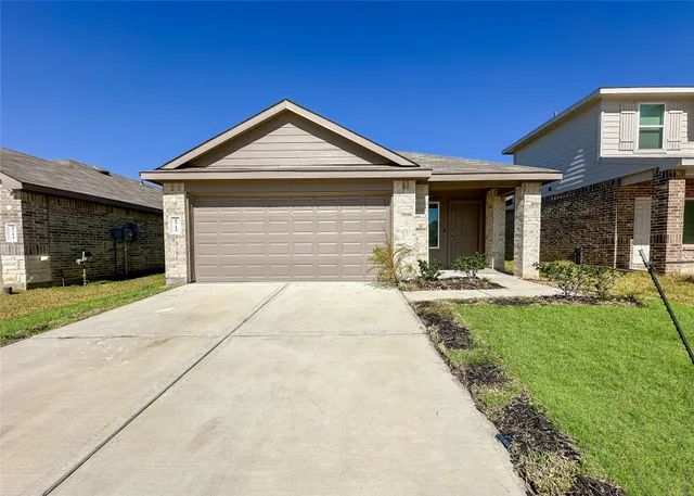 a front view of a house with yard and garage