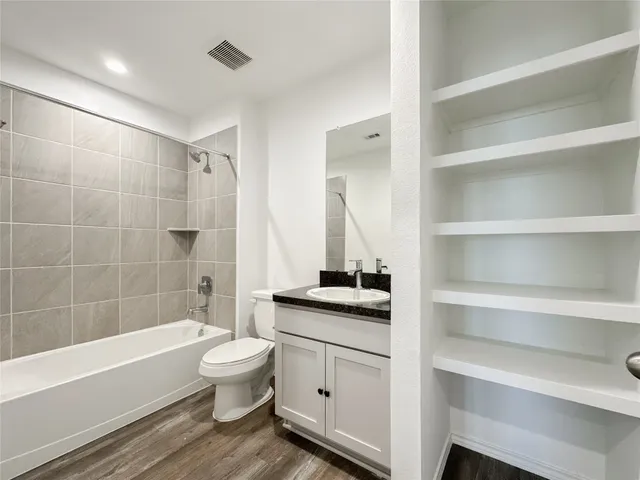 a bathroom with a granite countertop sink a toilet and bathtub